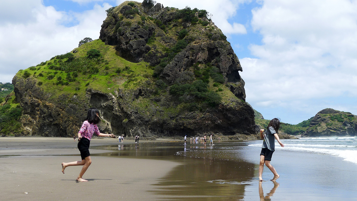 On the beach at Piha, by Lion Rock