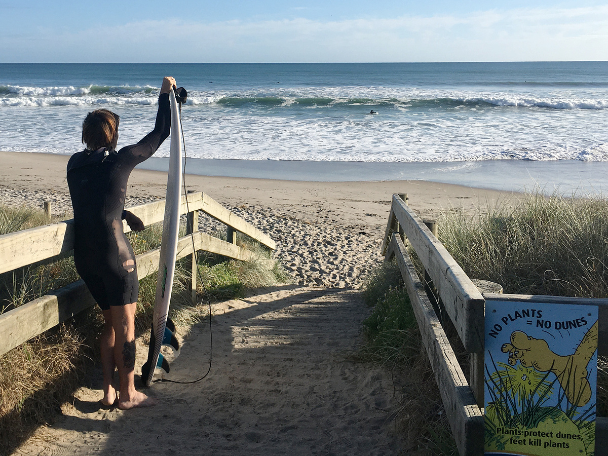 Surfer at Arataki Beach