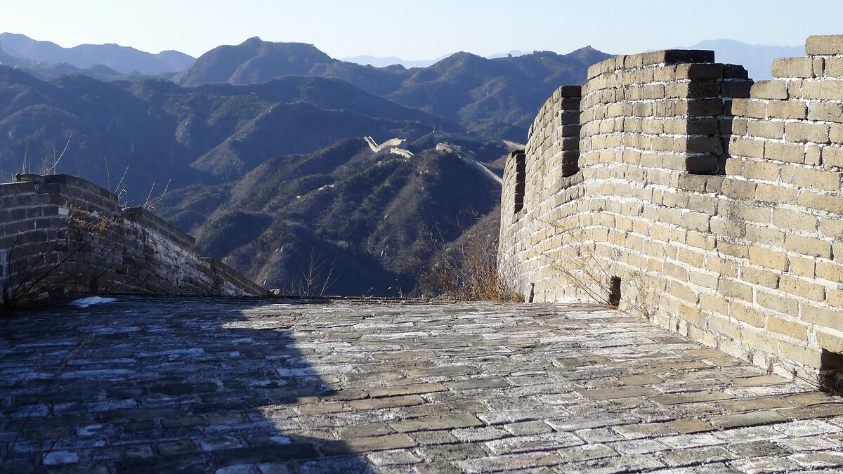 Great Wall and battlements in the foreground, with long views to more Great Wall on distant hills